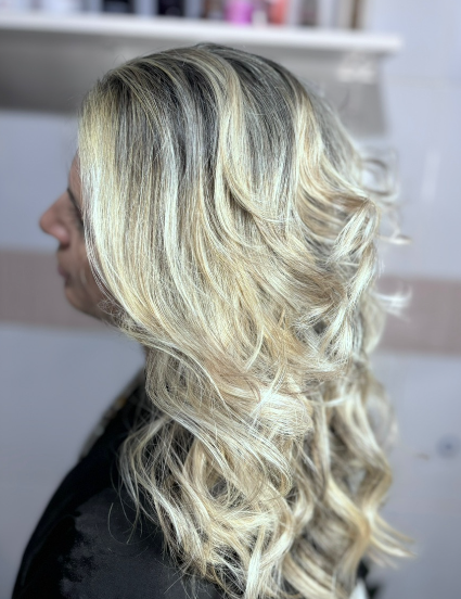 Cabelo loiro com mechas claras e ondas modeladas